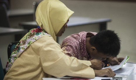 Petugas membantu peserta penyandang low vision saat ujian Seleksi Bersama Masuk Perguruan Tinggi Negeri (SBMPTN) 2017 di ruang F-MIPA Universitas Negeri Yogyakarta, (16/5).