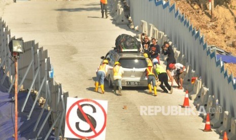 Petugas membantu sebuah kendaraan pemudik yang tidak kuat mendaki tanjakan darurat Kali Kenteng, di ruas tol fungsional Salatiga- Kartasura, Selasa (12/6) 