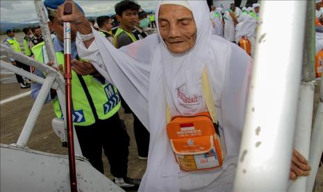 Petugas membantu seorang jamaah calon haji saat menaiki pesawat di Bandara Sultan Iskandar Muda, Aceh Besar, Aceh, Indonesia, Sabtu 20 Juni 2019. Panitia Penyelenggara Ibadah Haji (PPIH) Aceh membagi 12 kelompok terbang, sebanyak 393 JCH kloter 1 diberangkatkan dari Embarkasi Aceh. 