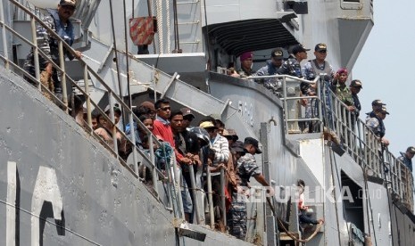 Petugas membantu warga eks anggota Gerakan Fajar Nusantara (Gafatar) saat tiba di Pelabuhan Kolinlamil Tanjung Priok, Jakarta Utara, Rabu (27/1).  (Republika/Yasin Habibi)