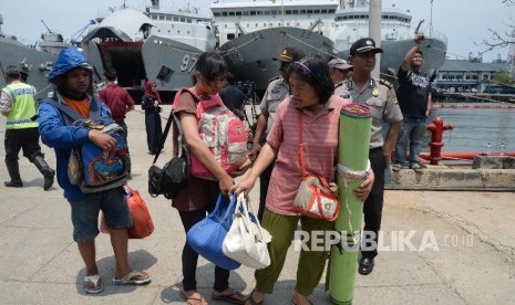 Petugas membantu warga eks anggota Gerakan Fajar Nusantara (Gafatar) yang baru turun dari KRI Banten saat tiba di Pelabuhan Kolinlamil Tanjung Priok, Jakarta Utara, Rabu (27/1).  (Republika/Yasin Habibi)