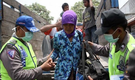  Petugas membantu warga korban erupsi Gunung Kelud turun dari truk ketika mengungsi di Balai Desa Tawang, Kecamatan Wates, Kediri, Jawa Timur, Jumat (14/2). 