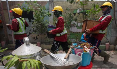 Petugas membantu warga mengangkut barang-barang milik warga yang rumahnya dibongkar di kawasan Tambak Osowilangun, Surabaya, Jawa Timur, Selasa (20/9/2022). Pemkot Surabaya melakukan pembongkaran 18 rumah secara bertahap dan telah berkekuatan hukum tetap (Inkracht) di kawasan dekat Sungai Branjangan guna membangun rumah pompa serta menormalisasi sungai itu. 