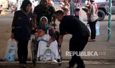 Petugas membatu Jamaah Haji Indonesia Kloter Pertama Debarkasi Jakarta Pondok Gede.