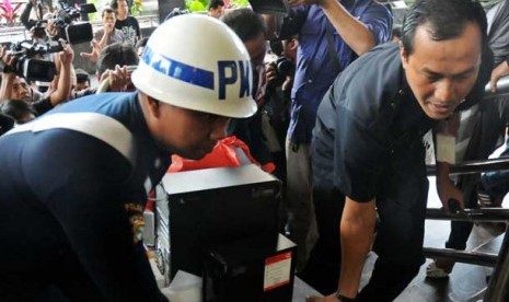 Petugas membawa barang bukti dari kantor PT Indoguna Utama di KPK, Jakarta, Rabu (30/1). 