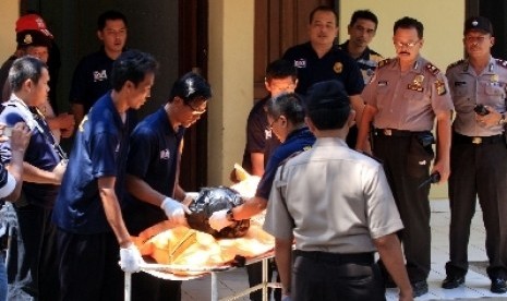 Petugas membawa kantong jenazah terduga teroris Solo di Rumah Sakit Polri Kramat Jati, Jakarta, Sabtu (1/9). 