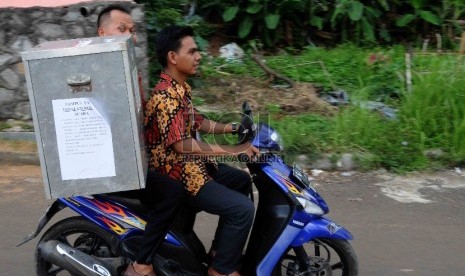  Petugas membawa kota suara hasil pemilihan kepala daerah (Pilkada) untuk dihitung di Kantor Kelurahan Pondok Jaya, Kecamatan, Cipayung, Kota Depok, Jawa barat, Rabu (9/12). (Republika/Agung Supriyanto)