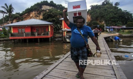 Petugas membawa kotak suara ketika melakukan pendistribusian logistik Pemilu 2019 di Kampung Kayu Pulo, Jayapura, Papua, Selasa (16/4/2019).