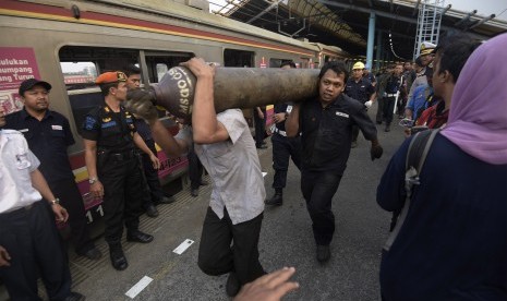 Petugas membawa tabung las untuk mengevakuasi masinis yang terjepit di gerbong ketika terjadi tabrakan Kereta Rel Listrik (KRL) di Stasiun Juanda, Rabu (23/9). 