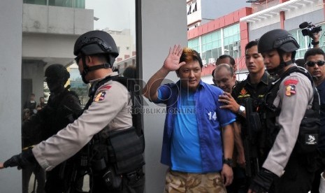 Petugas membawa tersangka Freddy Budiman dan sejumlah tersangka lain saat pengungkapan Kasus Pabrik Narkoba di Sebuah Ruko di kawasan Taman Palem, Cengkareng, Jakarta Barat, Selasa (14/4). (Republika/Rakhmawaty La'lang)