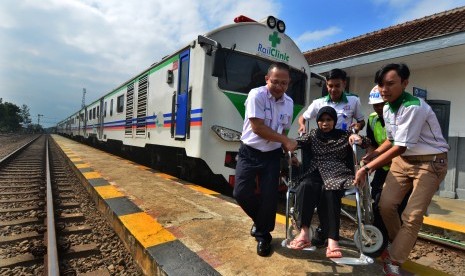 Petugas membawa warga menggunakan kursi roda usai mejalani pengobatan gratis Rail Clinic atau kereta kesehatan di Stasiun Ciawi, Kabupaten Tasikmalaya, Jawa Barat, Selasa (24/7)