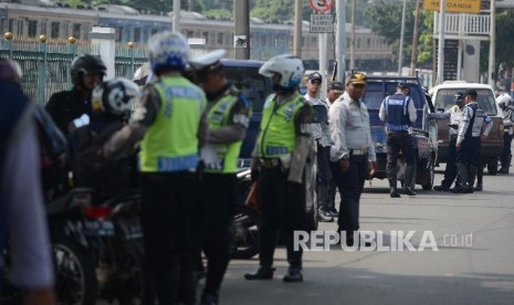 Petugas memberhentikan kendaraan untuk memeriksa kelengkapan surat kendaraan saat menggelar Operasi Zebra Jaya di Pasar Minggu, Kamis (17/11)