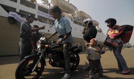 Petugas memberikan arahan kepada pemudik sepeda motor saat akan menaiki kapal saat pelepasan mudik gratis Pelni menggunakan KM Dobonsolo di pelabuhan penumpang Tanjung Priok, Jakarta , Sabtu (3/8). 