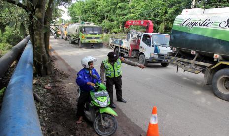 Petugas memberhentikan kendaraan di pos penyekatan (ilustrasi).