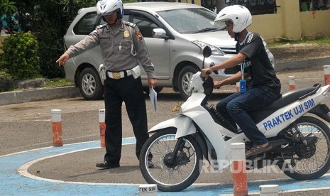 Petugas memberikan arahan saat praktek ujian pembuatan SIM di Polres Tegal, Jawa Tengah, Kamis (20/10). Menurut Satlantas Polres Tegal, sejak adanya pemberantasan pungli dan calo, pembuatan SIM menurun hingga 70 persen. 