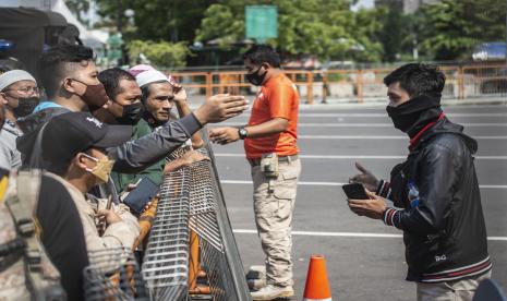 Petugas memberikan imbauan kepada warga yang akan berwisata untuk kembali pulang di depan pintu masuk Ancol Taman Impian, Jakarta, Sabtu (15/5/2021). Pengelola Ancol Taman Impian menutup seluruh area rekreasi dan wisata Pantai Ancol selama satu hari pada Sabtu (15/5) untuk dilakukan penyemprotan disinfektan dan evaluasi penguatan protokol kesehatan.