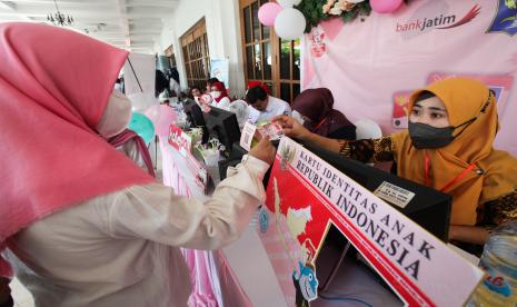 Petugas memberikan Kartu Identitas Anak (KIA) kepada pelajar saat Gebyar Hari Anak Nasional di Kompleks Balai Pemuda Surabaya, Jawa Timur, Rabu (27/7/2022). Berbagai macam kegiatan digelar dalam acara untuk memperingati Hari Anak Nasional tersebut seperti lomba mewarnai, pameran produk unggulan, pentas seni, pemberian penghargaan serta peluncuran sistem pembayaran nontunai KatePay bagi pelajar SD - SMP Surabaya dengan menggunakan Kartu Identitas Anak (KIA).