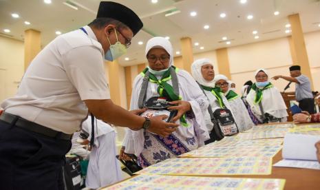 Petugas memberikan nomor urut kepada jamaah calon haji kelompok terbang (kloter) pertama embarkasi Medan di Asrama Haji Medan, Sumatera Utara, Jumat (10/6/2022). Sebanyak 391 jamaah calon haji asal Kota Medan, Kabupaten Mandailing Natal, Tapanuli Tengah dan Serdang Bedagai tiba di Asrama Haji Medan dan akan diterbangkan pada Sabtu (11/6). 