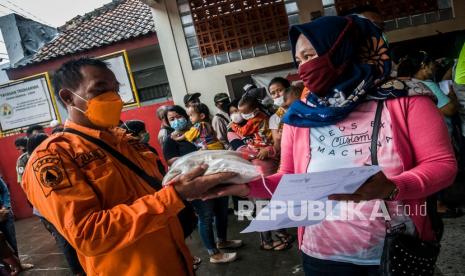 Petugas memberikan paket sembako kepada warga yang telah mengikuti vaksinasi COVID-19 di Vihara Ananda Avalokitesvara, Lebak, Banten, Rabu (15/12/2021). Pemerintah daerah setempat bekerjasama dengan Kepolisian Daerah Banten memberikan hadiah bantuan berupa paket sembako bagi warga yang mengikuti vaksin guna mempercepat capaian vaksinasi COVID-19 di Banten.