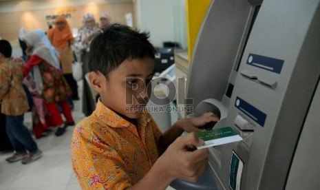 Petugas memberikan penjelasan kepada siswa kelas 5 sekolah alam Indonesia Jakarta saat melakukan kunjungan ke Bank Syariah Mandiri di Jakarta, Selasa (20/1).( Republika/Prayogi)