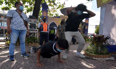 Petugas memberikan sanksi push up kepada pelanggar protokol kesehatan di Posko Uma Anyar, Kota Denpasar, Bali, Senin (10/5/2021). 