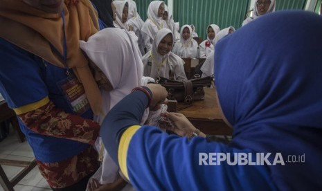 Petugas memberikan vaksin Measless Rubella (MR) kepada pelajar saat acara Pencanangan Kampanye Imunisasi MR di Madrasah Tsanawiah 10, Sleman, DI Yogyakarta, Senin (1/8). 