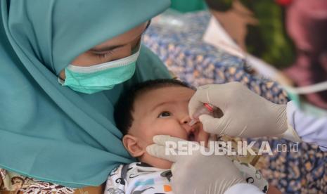 Petugas memberikan vaksin polio dengan cara diteteskan ke mulut bayi saat berlangsung imunisasi di Posyandu Kuta Alam, Banda Aceh, Aceh, Selasa (2/2/2021). 