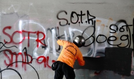 Petugas membersihkan coretan yang dibuat oleh anak muda sahur on the road (SOTR) di kolong Semanggi, Jakarta Pusat.