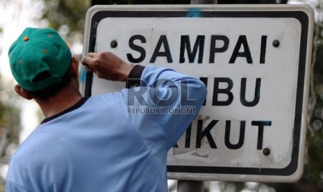  Petugas membersihkan dan menulis ulang rambu lalu lintas (ilustrasi)