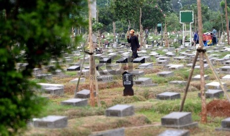 Petugas membersihkan komplek makam di TPU Menteng Pulo, Jakarta Selatan, Jumat (27/11). 