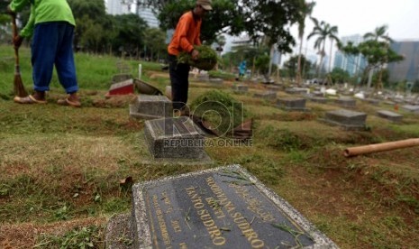 Petugas membersihkan komplek makam di TPU Menteng Pulo, Jakarta Selatan, Jumat (27/11).