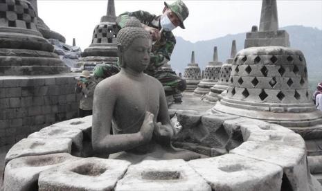 Petugas membersihkan patung Budha di Candi Borobudur, Magelang, Jawa Tengah. PT Taman Wisata Candi Borobudur, Prambanan & Ratu Boko (Persero) atau TWC melakukan penutupan seluruh destinasi yang dikelolanya.