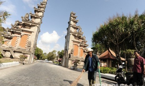 Petugas membersihkan puing-puing bangunan gapura gerbang masuk kawasan The Nusa Dua yang runtuh akibat gempa di Badung, Bali, Selasa (16/7/2019). 