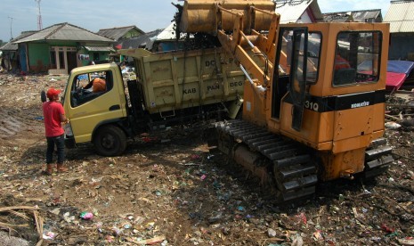 Petugas membersihkan puing-puing rumah dan sampah pasca terjangan tsunami Selat Sunda di Kampung Teluk Nelayan I, Labuan, Pandeglang, Banten, Rabu (9/1/2019). 