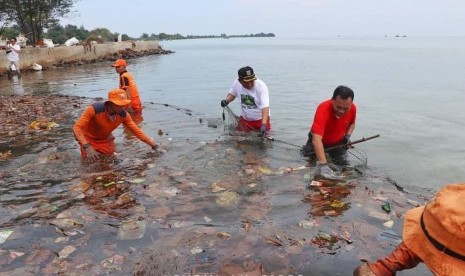 Petugas membersihkan sampah di Pulau Pari, Kepulauan Seribu, Kamis (29/11). 