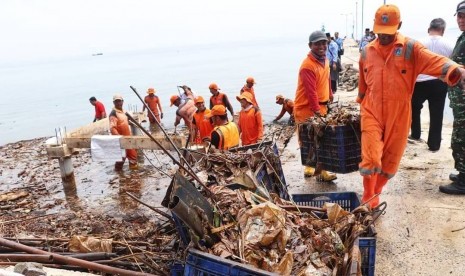 Petugas membersihkan sampah di Pulau Pari, Kepulauan Seribu, Kamis (29/11). 