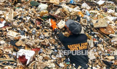 Petugas membersihkan sampah yang menumpuk di Kali Baru Cijantung, Cimanggis, Depok, Jawa Barat, Sabtu (23/1). 