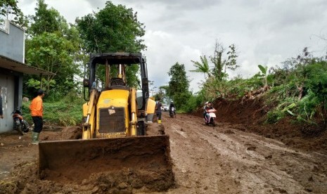 Petugas membersihkan sisa material longsoran yang menutup badan Jalan Cisinga, tepatnya di Kampung Sukasukur, Desa Karangsembung, Kecamatan Jamanis, Kabupaten Tasikmalaya, Rabu (18/12). 