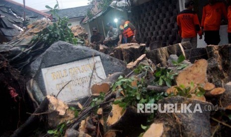 Petugas membersihkan sisa-sisa pohon beringin tua yang rubuh dan menimpa gedung Balai Tanjung, Kompleks Kepatihan, Yogyakarta, Selasa (28/11). Salah satu beringin tua di kantor gubernur DIY tersebut ambruk karena diterpa hujan dan angin.