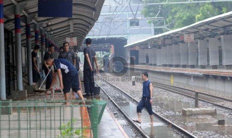 Petugas membersihkan Stasiun Sudirman di Jakarta Pusat,Kamis (17/1), yang ditutup sementara akibat banjir.  (Republika/Aditya Pradana Putra)