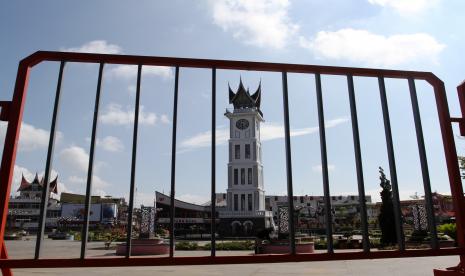 Petugas membersihkan taman di area objek wisata Jam Gadang di Bukit Tinggi, Sumatera Barat, Sabtu (8/5/2021). Pemerintah Kota Bukittinggi akan membatasi wisatawan yang berkunjung ke objek wisata Jam Gadang selama liburan hari raya Idul Fitri 1442 H, agar tidak ada kerumunan di area tersebut.