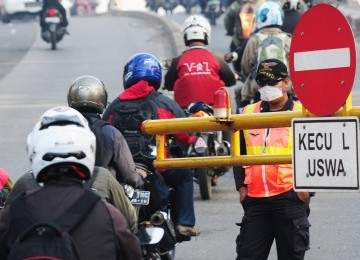 petugas membiarkan sejumlah sepeda motor masuk ke jalur khusus Bus TransJakarta (Busway), Jalan Warung Buncit Raya, Jakarta Selatan, Selasa (17/1). (Republika/Aditya Pradana Putra)