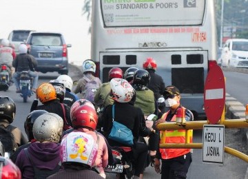 petugas membiarkan sejumlah sepeda motor masuk ke jalur khusus Bus TransJakarta (Busway), Jalan Warung Buncit Raya, Jakarta Selatan, Selasa (17/1). (Republika/Aditya Pradana Putra)