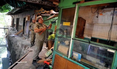 Petugas membongkar bangunan di tepi rel Stasiun Tebet, Jakarta, Senin (18/8). (Republika/ Wihdan).