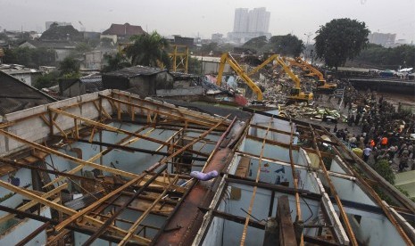 Petugas membongkar bangunan menggunakan alat berat di kawasan Kalijodo, Jakarta, Senin (29/2).