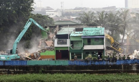 Petugas membongkar bangunan menggunakan alat berat di kawasan Kalijodo, Jakarta, Senin (29/2).