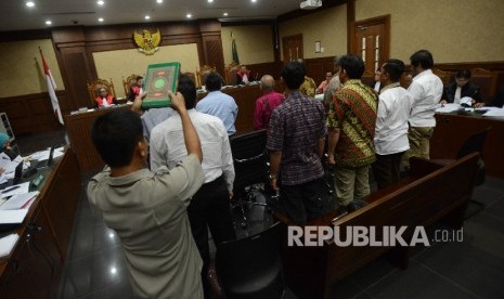 Petugas memegang Kitab Suci Al-Quran saat menyumpah saksi untuk memberikan keterangan dalam sidang dengan dua terdakwa kasus korupsi e-KTP Irman dan Sugiharto di Pengadilan Tipikor, Jakarta, Kamis (13/4).