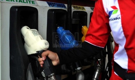  Petugas memegang nozzle saat akan mengisi tangki dengan Bahan Bakar Minyak