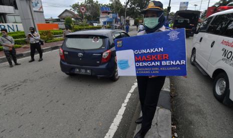 Petugas memegang papan imbauan saat menggelar operasi yustisi protokol kesehatan di Palu, Sulawesi Tengah, Kamis (24/9/2020). Operasi gabungan TNI, Polri bersama pemerintah setempat tersebut guna menertibkan masyarakat agar disiplin menerapkan protokol kesehatan guna mencegah penyebaran COVID-19 yang semakin meningkat di daerah tersebut.