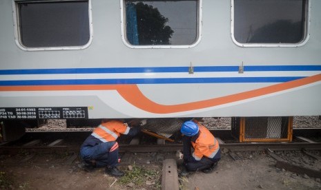 Petugas memeriksa bagian bawah gerbong yang rusak akibat anjloknya kereta api di Nagreg, Kabupaten Bandung, Jawa Barat, Selasa (4/6/2019). 